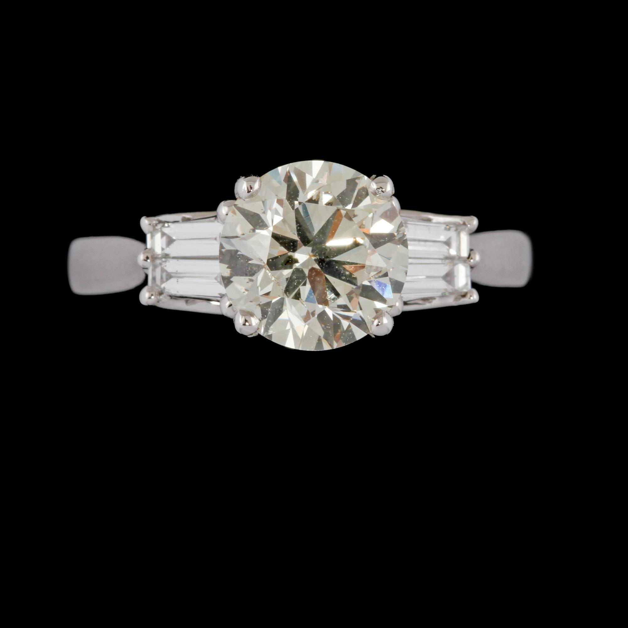 RING, 18K vitguld med briljantslipad diamant 2.00 ct samt 4 baguettslipade diamanter 0.31 ct. Vikt 4,5 gram.