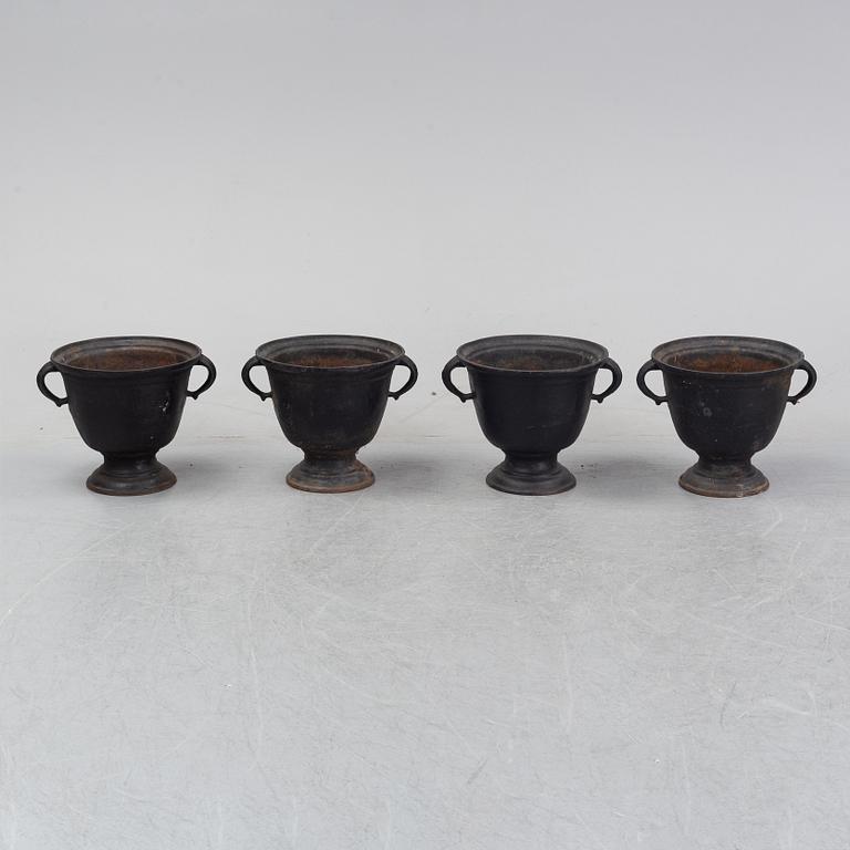 A set of four cast iron garden urns, 20th century.