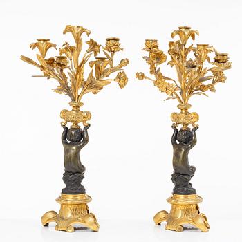A Rococo style mantle clock and pair of candelabra, France, late 19th Century.