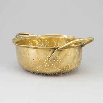 A 19th century brass colander.