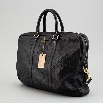 Gucci, a monogram leather bag/laptop-bag.
