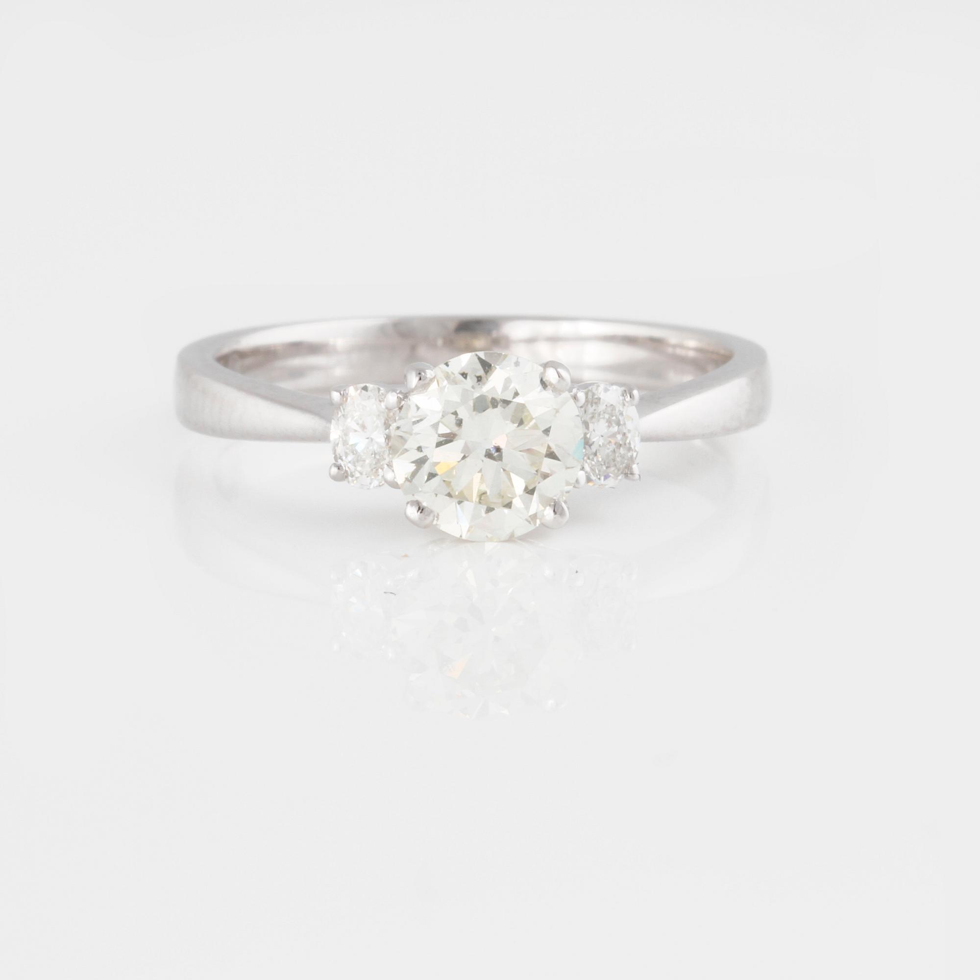 RING, med briljantslipad diamant 0.88 ct samt 2 ovalslipade små diamanter.
