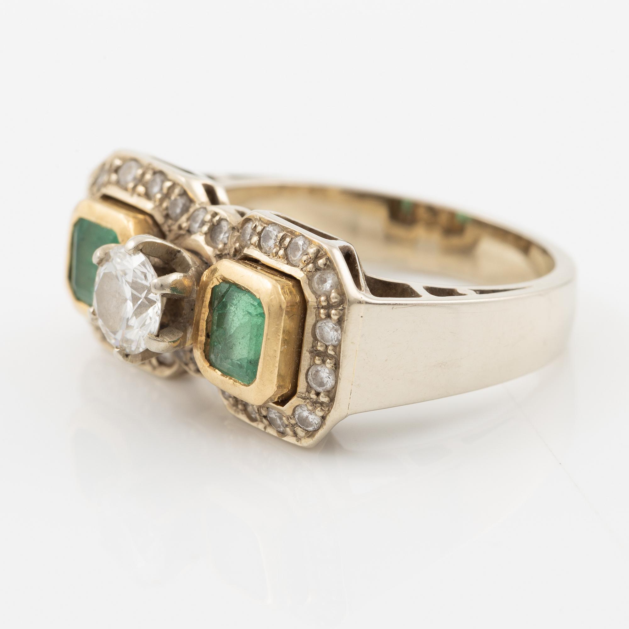 Ring, 18K vitguld med briljantslipad diamant ca 0.65 ct samt två smaragder.