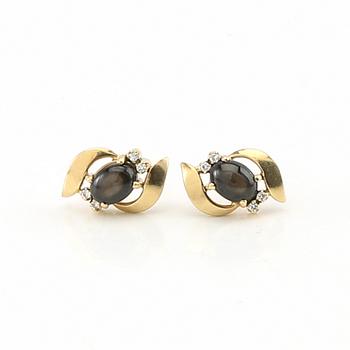 Ring and earrings in 14K gold with round brilliant-cut diamonds and likely natural black star sapphires.