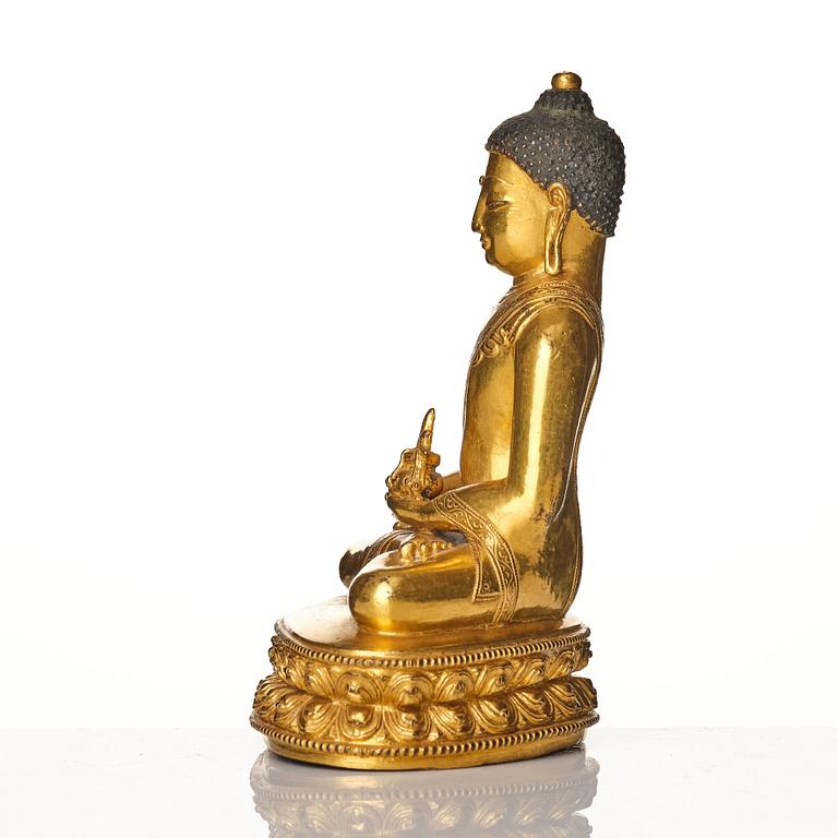 A gilt copper alloy figure of buddha, Tibeto Nepalese, stylistically from the 14th/15th Century,