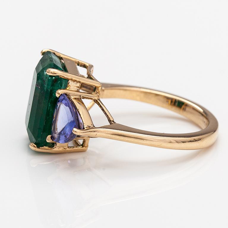A 14K gold ring with tanzanites and a ca 5.80 ct emerald.