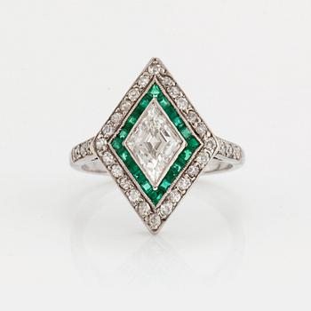 A RING set with diamonds and emeralds.