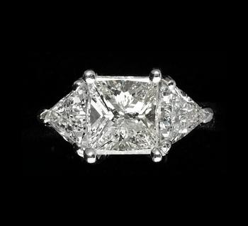 144. RING, princess cut diamond, 2.11 cts, with triangular cut diamonds, tot. 1.45 cts.