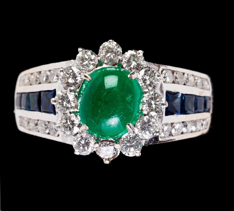 RING, cabochonslipad smaragd, blå safirer samt briljantslipade diamanter, tot. 1.10 ct.
