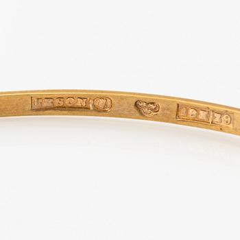 An 18K gold bangle.