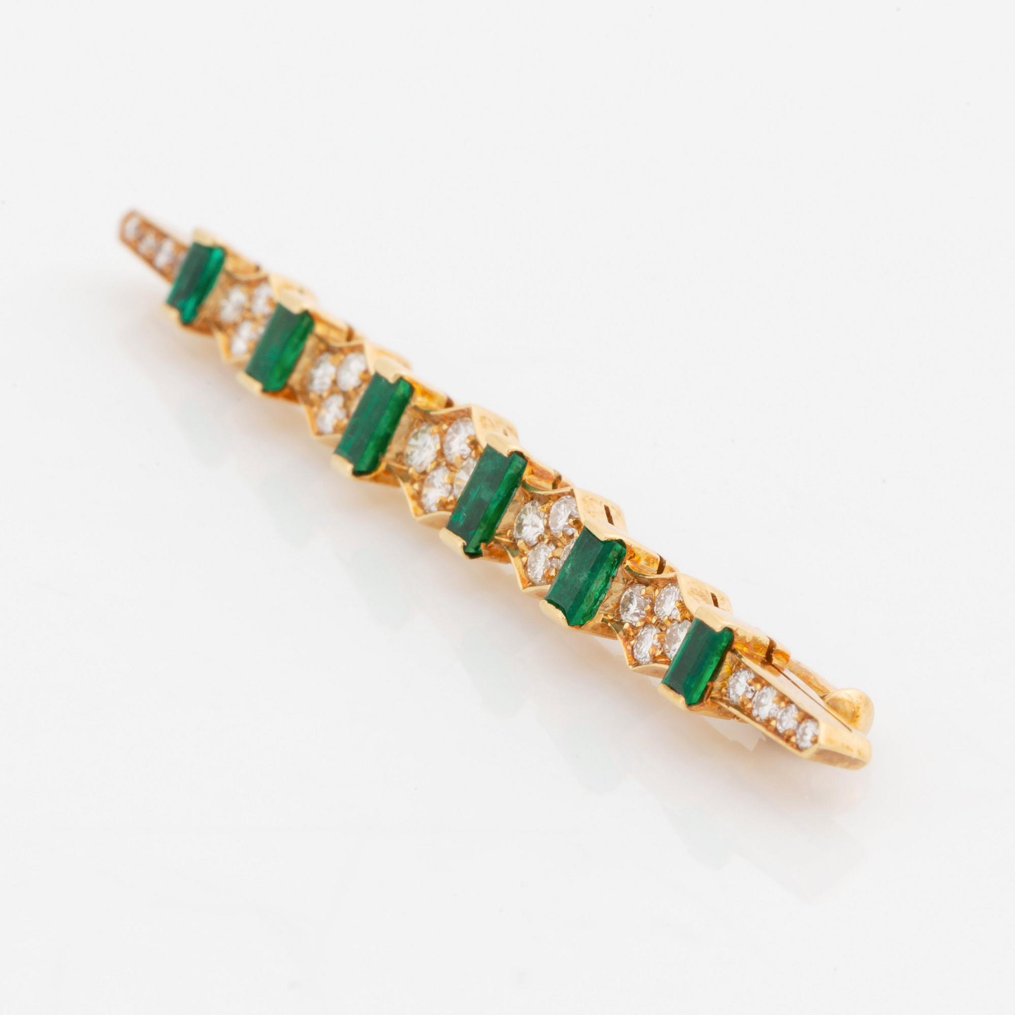 An 18K gold brooch set with step-cut emeralds and round brilliant-cut diamonds.