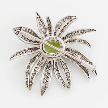 An 18K white gold brooch set with a faceted peridot and eight-cut diamonds.