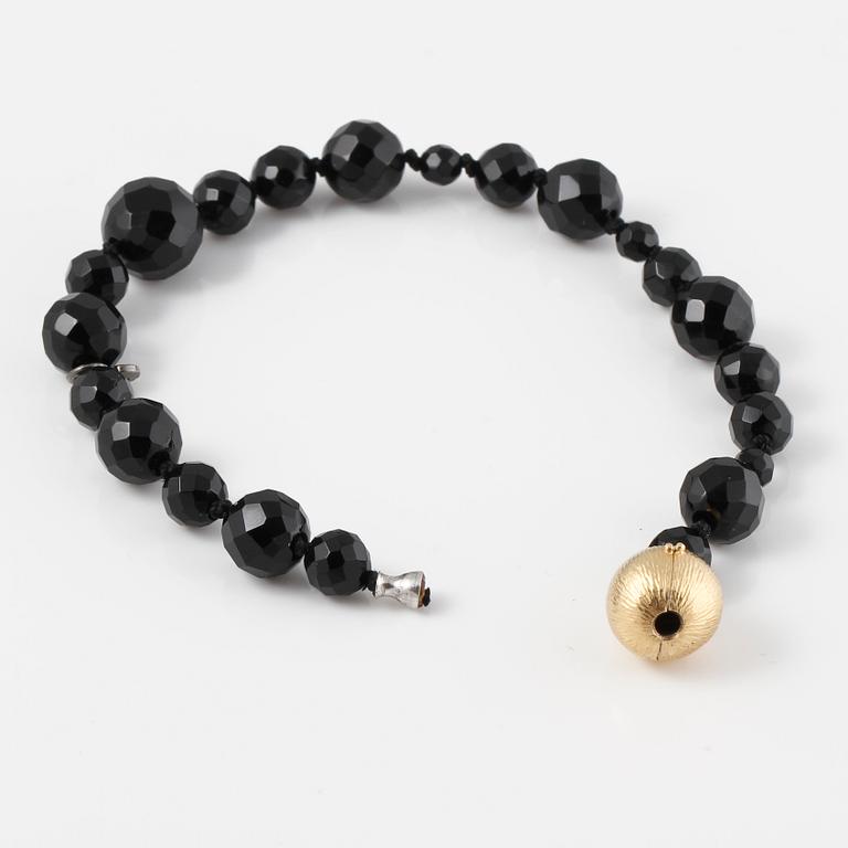 ARMBAND, fasettslipad onyx med lås i 18 K guld, Ole Lynggaard.