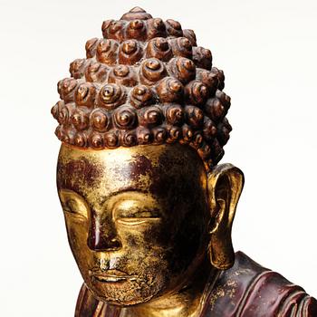 A large gilt and lacquered figure of a seated buddha, Qing dynasty, 19th Century.