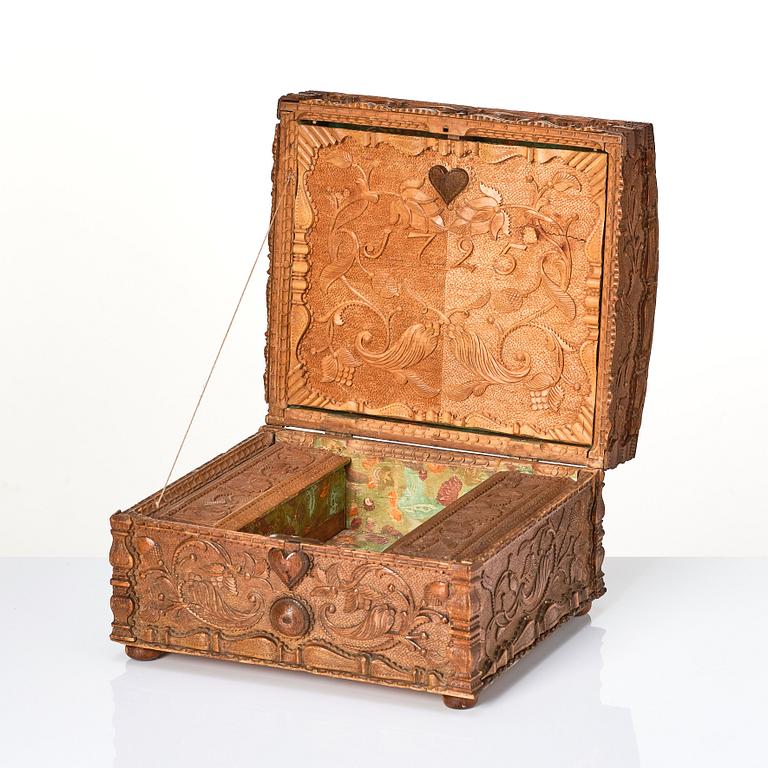 A baroque wedding casket, carved wood, dated 1725.