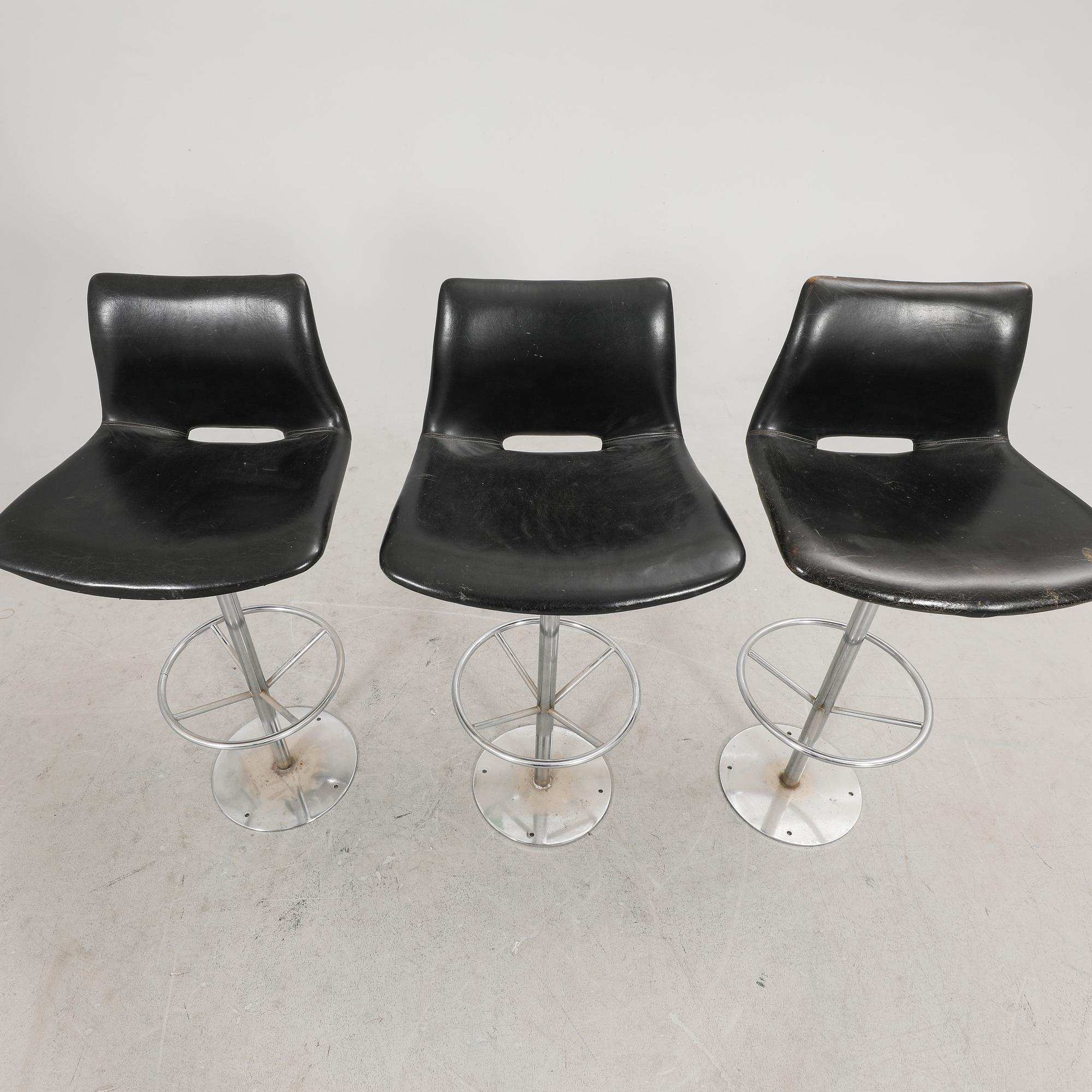 A set of three late 20th century metal and leather bar stools.