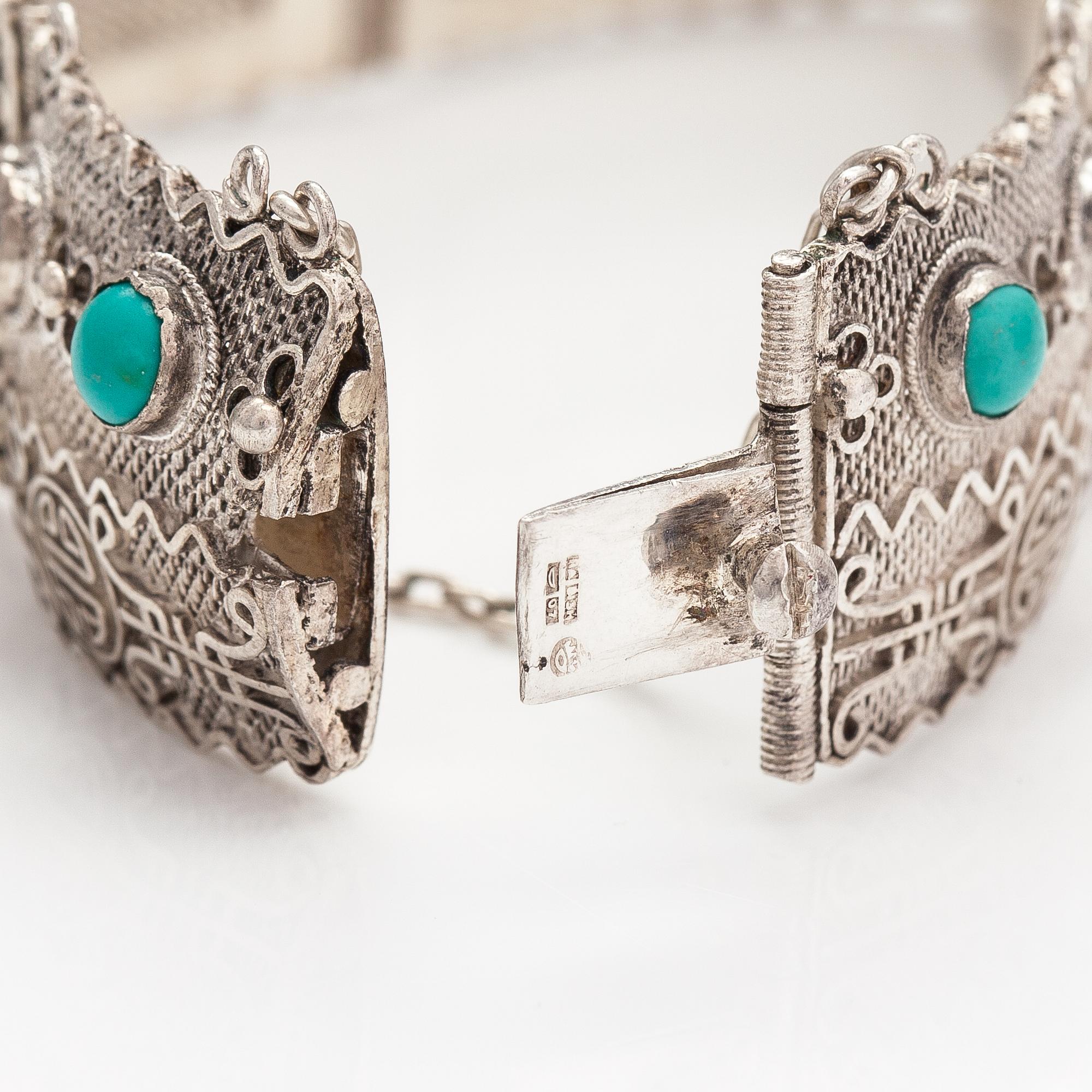 A silver bracelet and ring with turquoises. China.