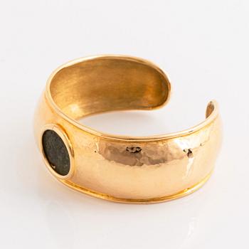 An 18K gold bangle set with an ancient coin.