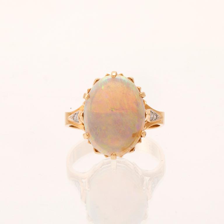 A 14K red and white gold ring with an oval-cut opal and round brilliant-cut diamonds.
