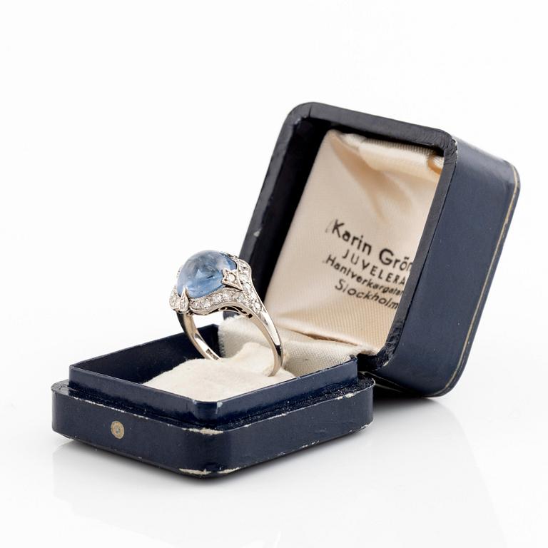 An 18K gold ring set with a cabochon-cut sapphire and eight-cut diamonds.
