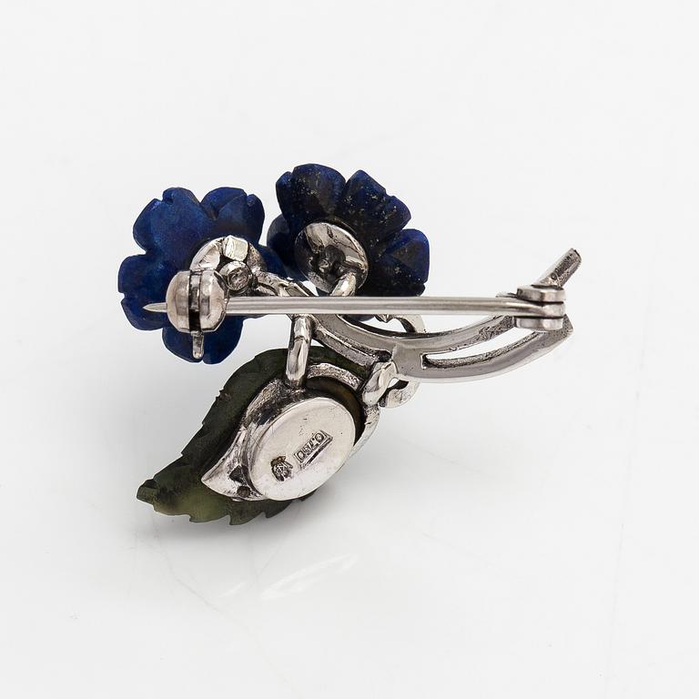 Brosch, nickelhaltigt 18K vitguld, lapis lazuli, nefrit och diamanter ca 0.03 ct totalt.