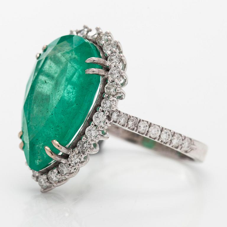 A 14K white gold ring, with a pear-cut  emerald ca. 7.72 ct and diamonds.