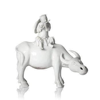 1025. A blanc de chine figure of a boy on an ox, late Qing dynasty.