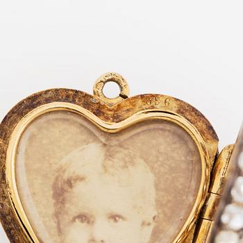 A pendant/locket in 18K gold set with old-cut diamonds, in the form of a heart.