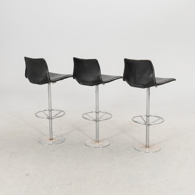 A set of three late 20th century metal and leather bar stools.