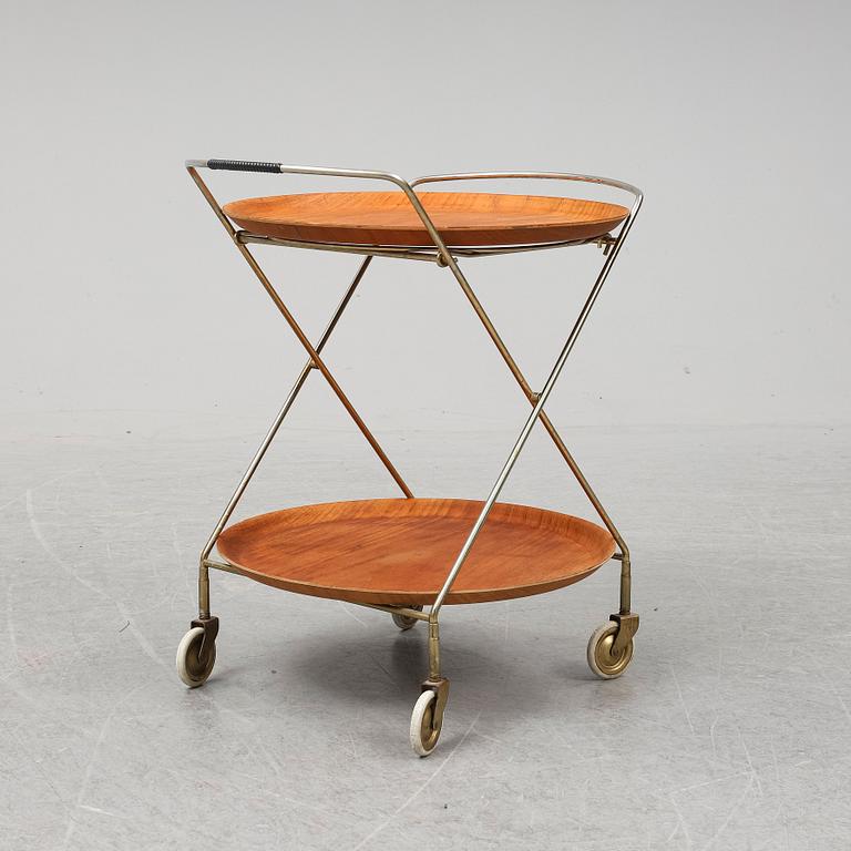 A drinks trolley from J-H Fabrikerna, Sävsjö, 1960-tal.Två lösa, runda brickor fanerade med teak. Märkta J-H Fabrikerna.