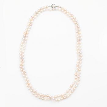Long cultured pearl necklace with an 18K white gold clasp set with emeralds.