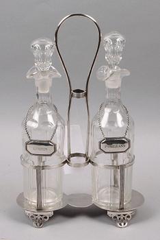 FLASKSTÄLL med FLASKOR, 2 st. Nysilver och glas. Sekelskiftet 1800/1900.
