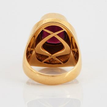 A Sigurd Persson 18K gold ring set with a faceted garnet.