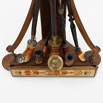 A pipestand and four pipes, circa 1900.