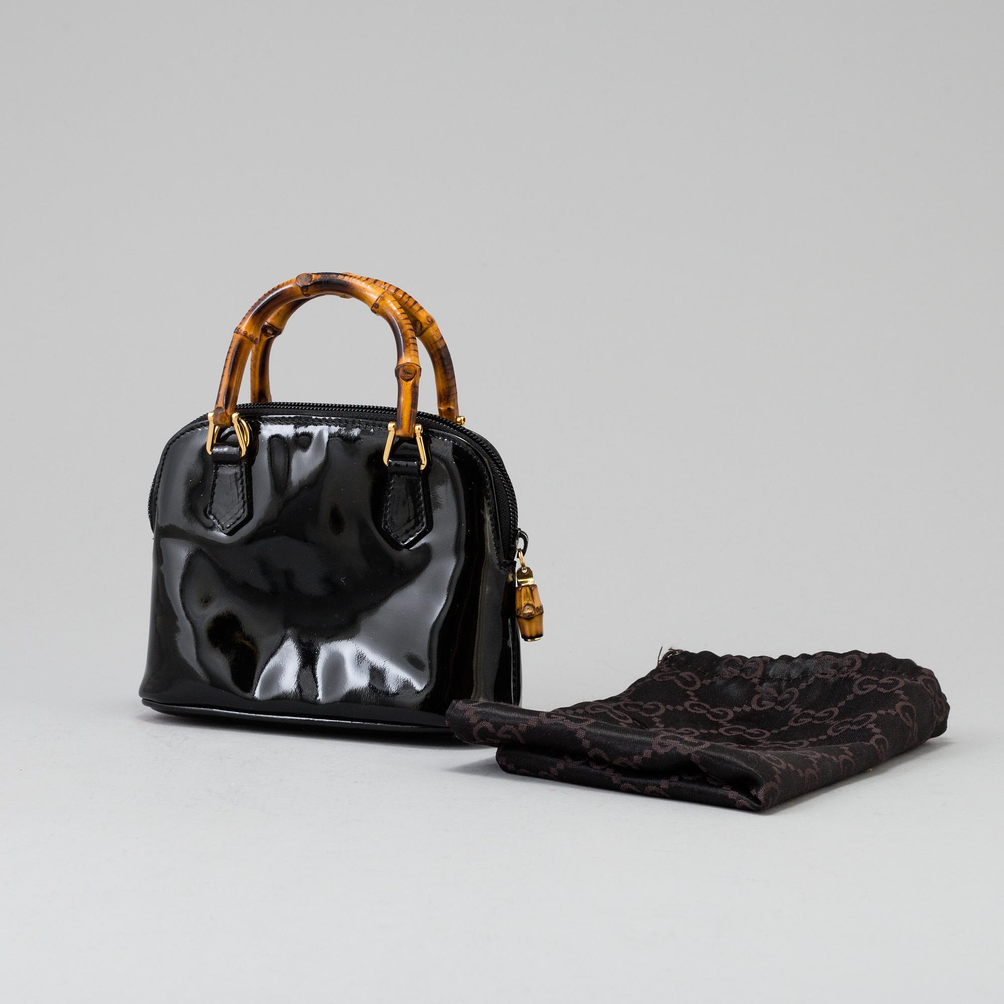A Gucci patent leather bag with bamboo handle.