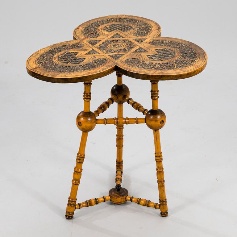 A wooden table from around 1900, cut decor.