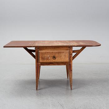 A 19th Century table with drop leaves.