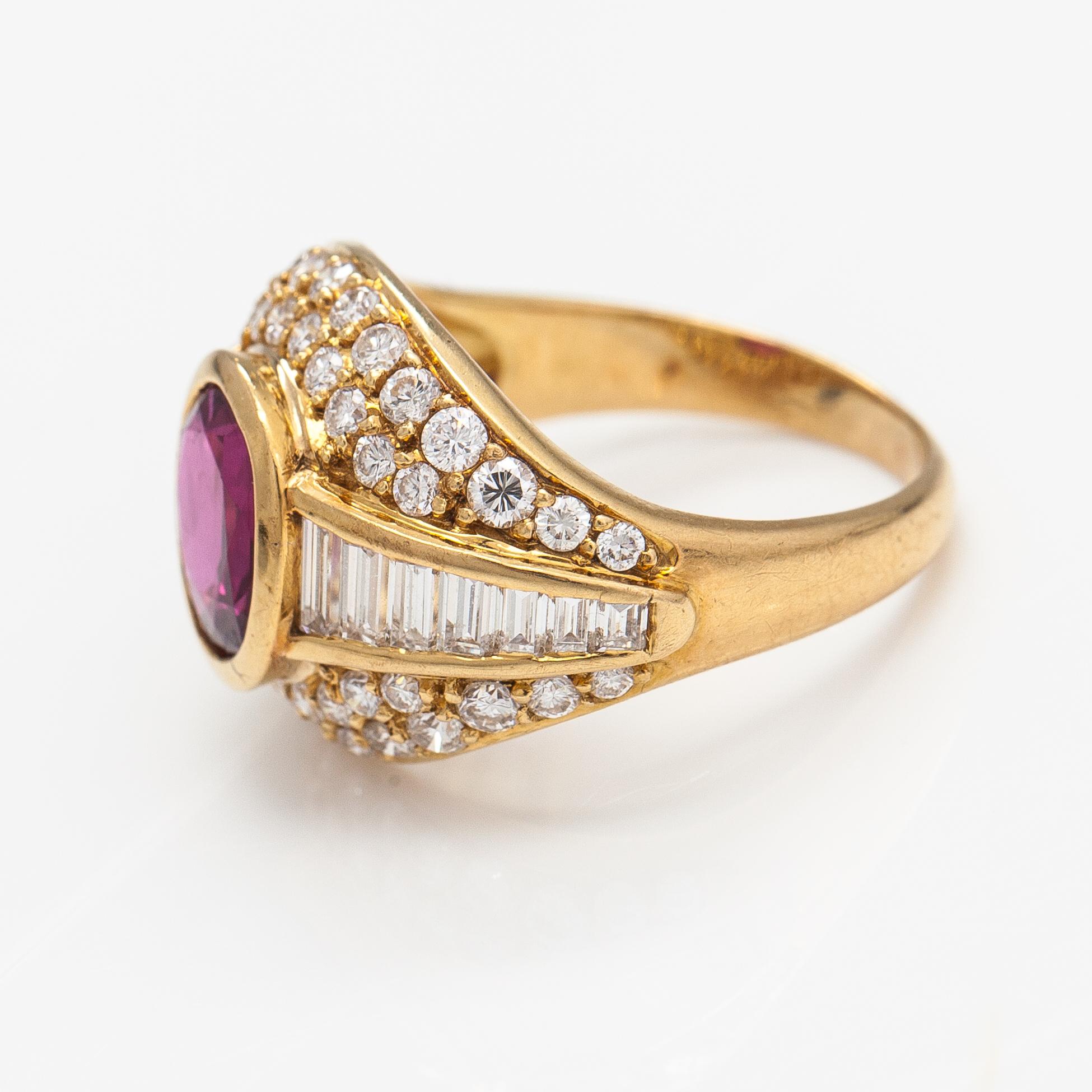 An 18K gold ring with baguette and brilliant cut diamonds and a ruby.