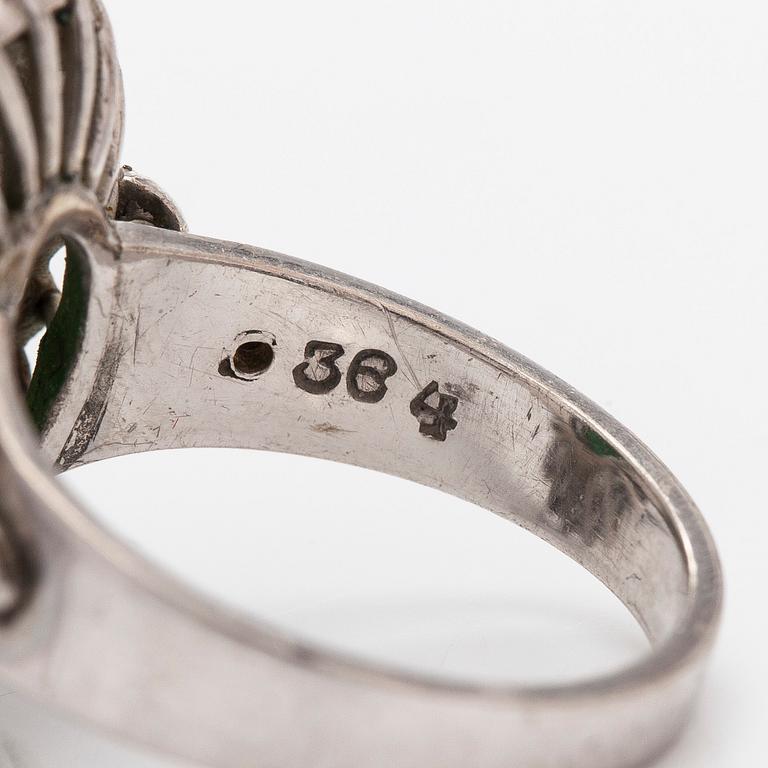A palladium-plated silver ring with cabochon-cut jadeite and diamonds.