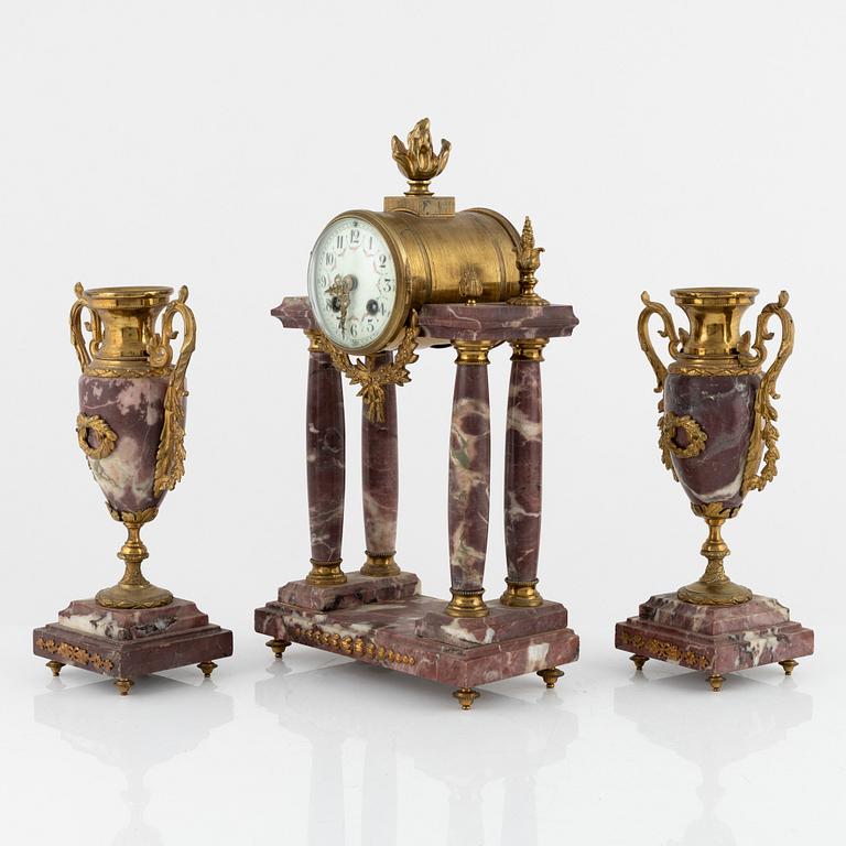 A Louis XVI-style Mantle Clock and a pair of decorative urns, early 20th Century.