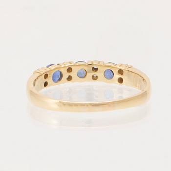 Ring 18K guld med runda briljantslipade diamanter och runda fasetterade blå stenar, London England.