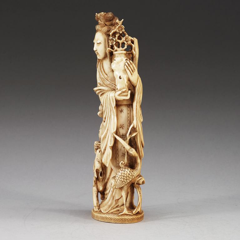 A carved ivory figure of a lady with a deer, crane and a flower vase, late Qing dynasty, 19th Century.