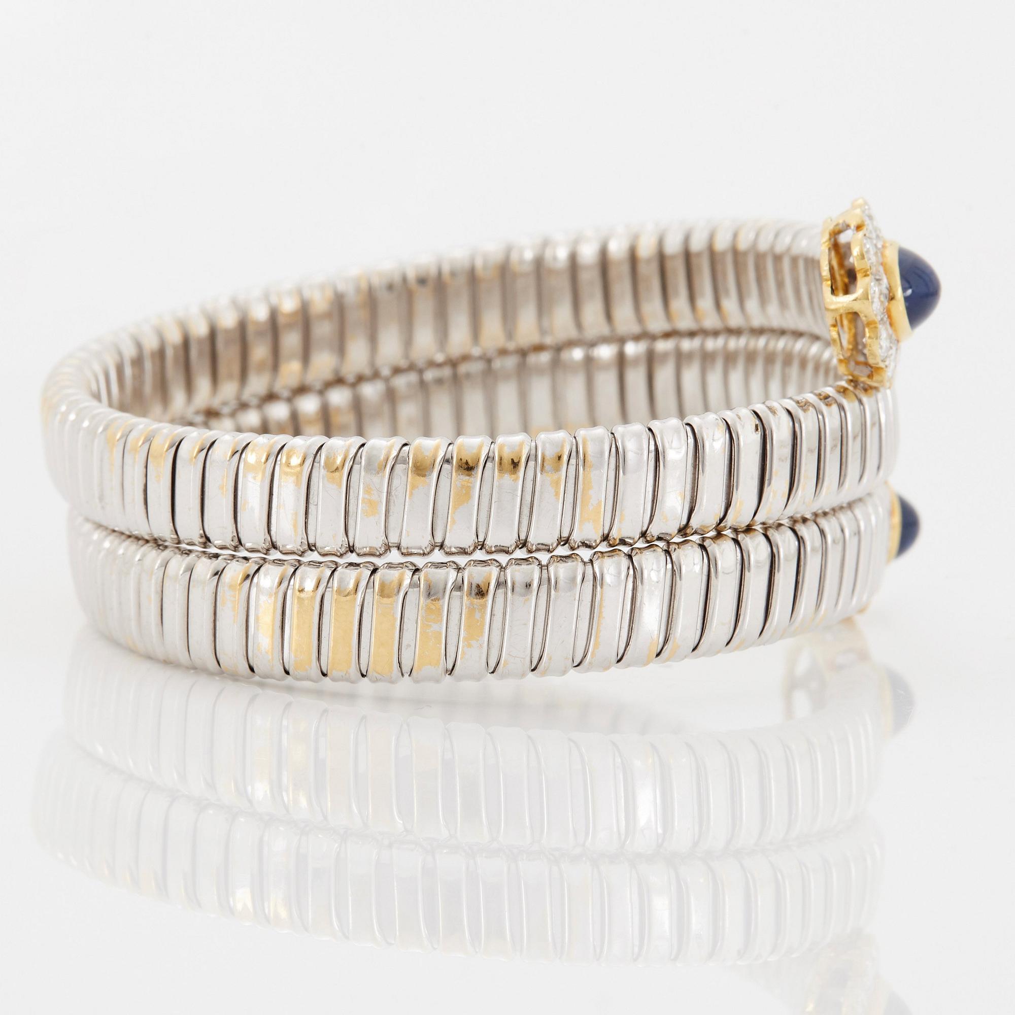 An 18K gold bangle set with cabochon-cut sapphires and round brilliant-cut diamonds.