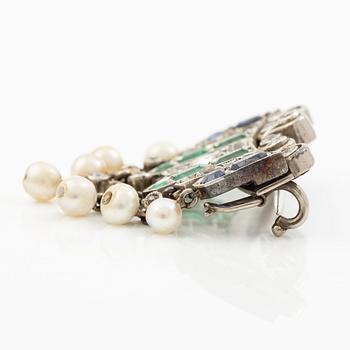 Brooch in platinum set with old-cut diamonds, sapphires, emeralds, and pearls.
