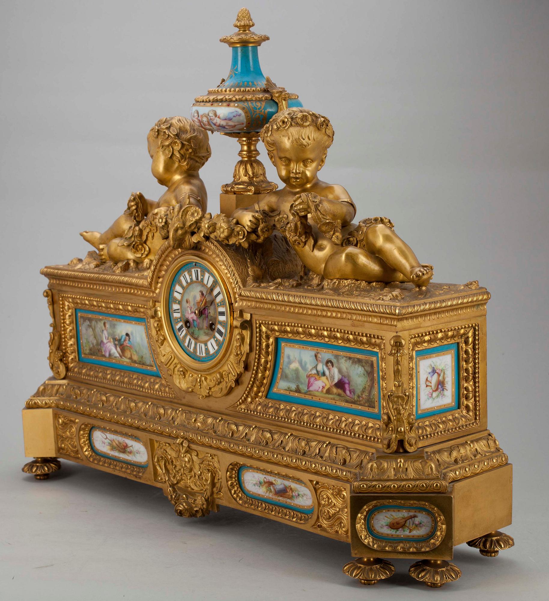 BORDSPENDYL. Förgylld brons med målade porslinsdekorationer i Sevres stil.Ca 1880.