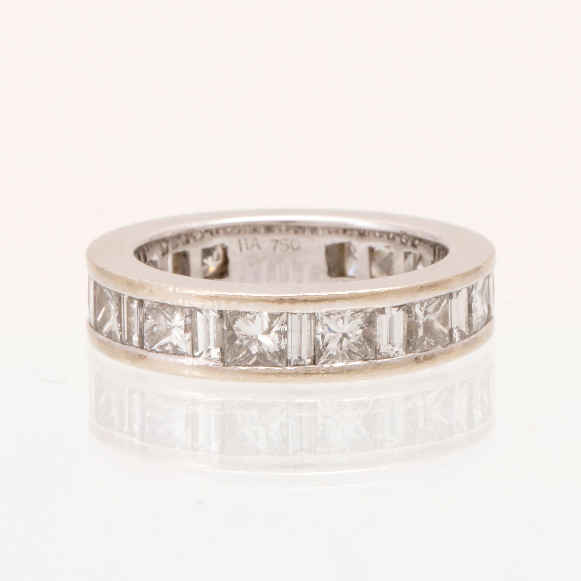 An 18K white gold eternity ring set with baguette and princess cut diamonds by Hartmann's Denmark.