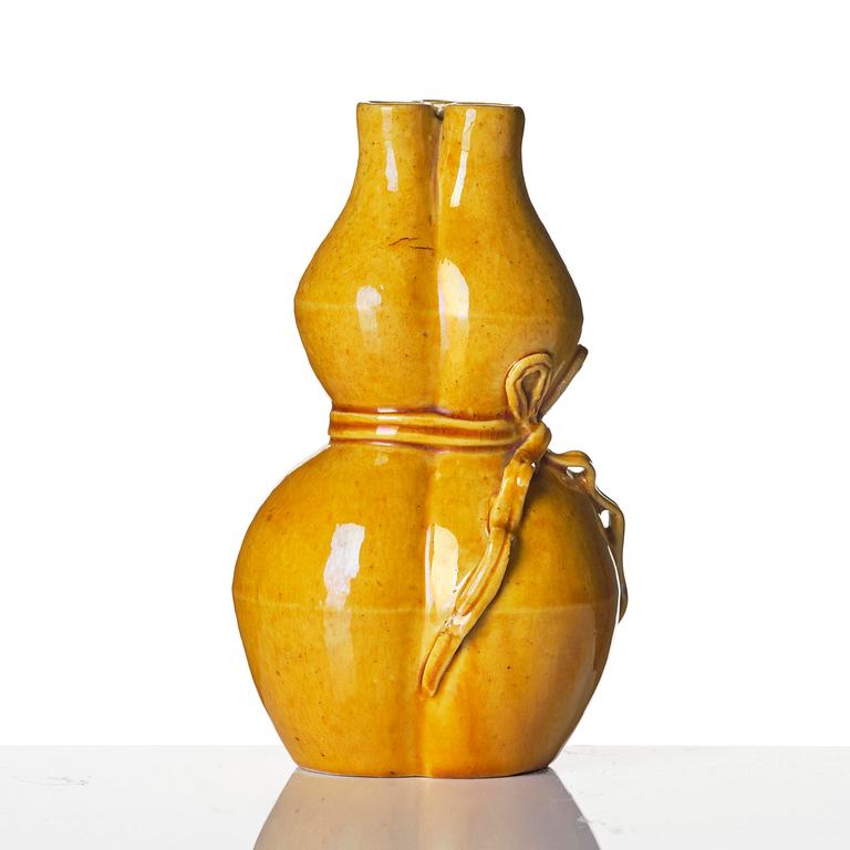 A yellow glazed triple spouted double gourd vase, Qing dynasty, 18th century.