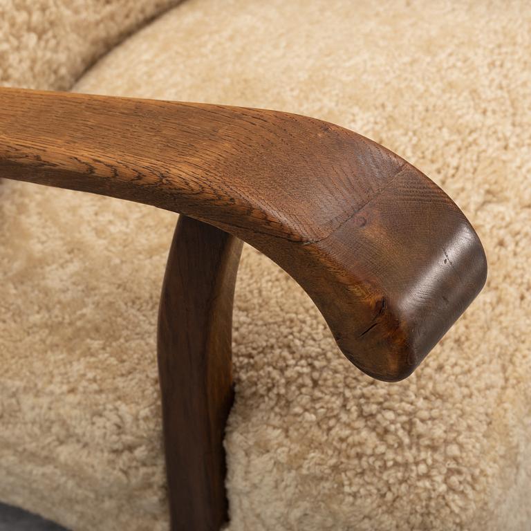 A pair of Danish lounge chairs with sheepskin upholstery.