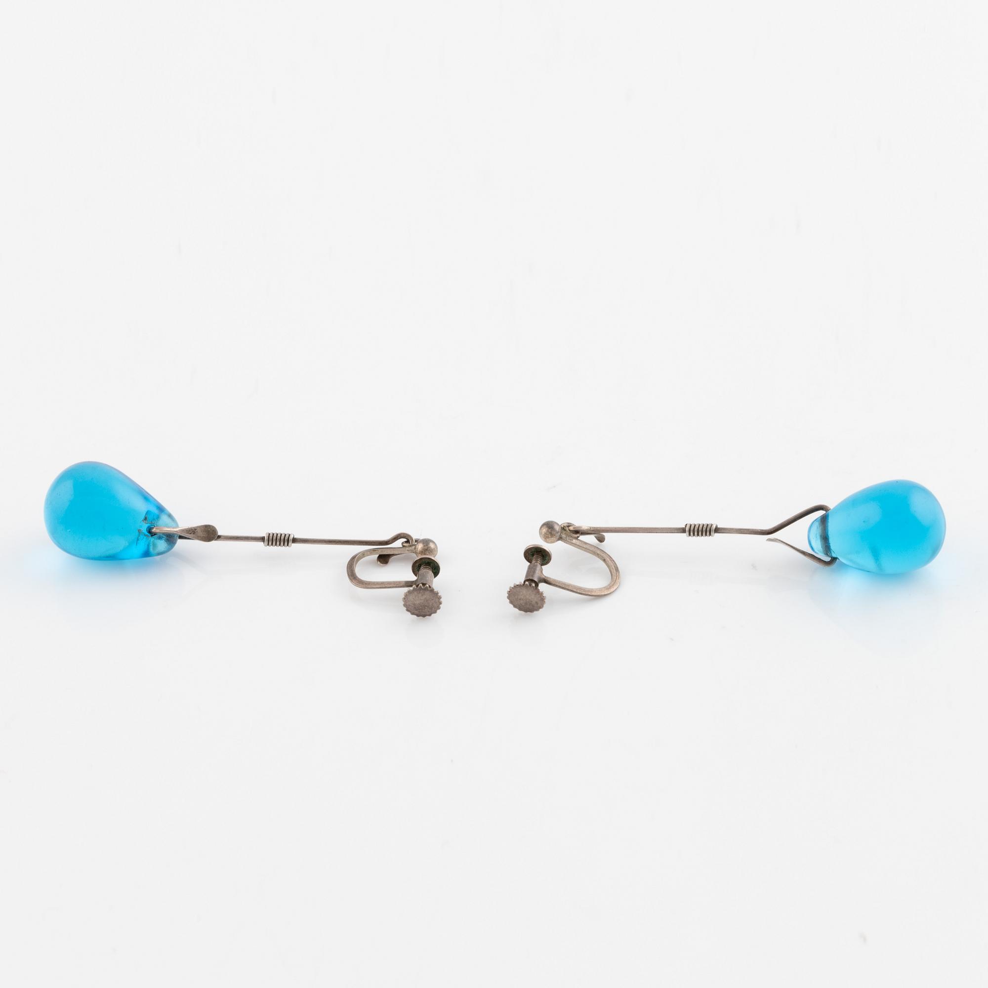A pair of silver earrings with blue glass drops, likely by Torun Bülow-Hübe.