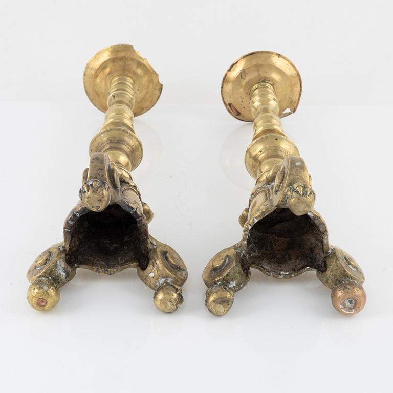 A pair of brass candle sticks, around 1700.